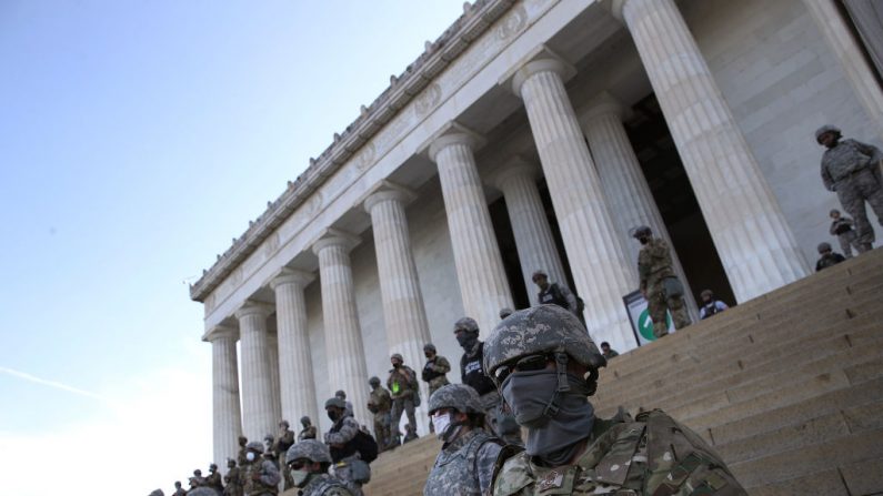 Miembros de la Guardia Nacional de D.C. se paran en los escalones del Monumento a Lincoln mientras los manifestantes participan en una protesta contra la brutalidad policial y la muerte de George Floyd, el 2 de junio de 2020 en Washington, DC. (Win McNamee/Getty Images)
