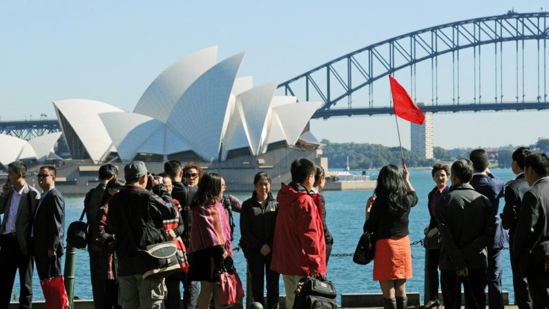 Un grupo de turistas asiáticos llega para fotografiarse frente a la Casa de la Ópera y el Puente del Puerto de Sydney, en esta foto tomada el 8 de mayo de 2012. (Greg Wood/AFP/GettyImages)