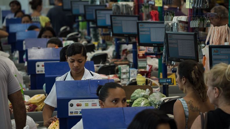 La gente espera en las cajas de un supermercado en Río de Janeiro, Brasil, el 21 de diciembre de 2015. (YASUYOSHI CHIBA/AFP a través de Getty Images)