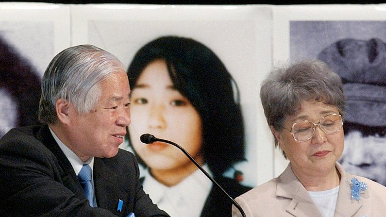 TOKIO, JAPÓN: Shigeru Yokota (L), el padre de Megumi Yokota (en la foto de fondo), que fue secuestrada por agentes norcoreanos en 1977 cuando tenía 13 años, habla ante unas 6.000 personas durante un mitin en un parque de Tokio, el 24 de abril de 2005, mientras su esposa y la madre de Megumi, Sakie, observan. (El crédito de la foto debe leerse AFP/AFP vía Getty Images)
