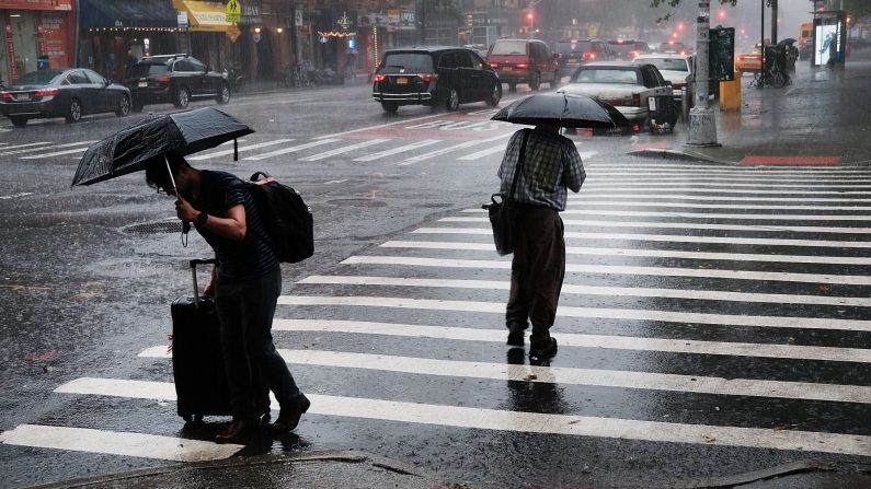 Gente caminando bajo la lluvia mientras las tormentas eléctricas severas se mueven por la región el 19 de junio de 2017 en la ciudad de Nueva York. (Spencer Platt/Getty Images)