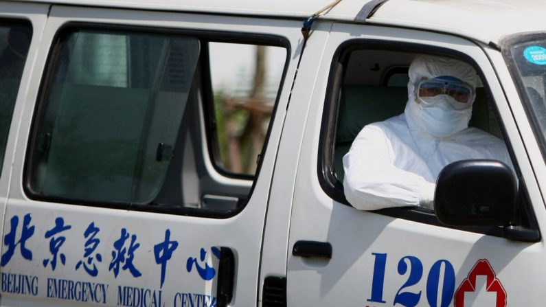 Un trabajador del hospital se sienta en una ambulancia en el hospital Ditan en Beijing el 17 de mayo de 2009. (Feng Li/Getty Images)