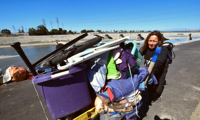 Melissa Lanning saca su carro de pertenencias junto al río Santa Ana en Anaheim, California, el 20 de febrero de 2018. (Frederic J. Brown/AFP vía Getty Images)