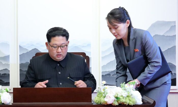 El líder de Corea del Norte, Kim Jong Un (iz), firma el libro de visitas junto a su hermana Kim Yo Jong (de) durante la cumbre intercoreana con el presidente de Corea del Sur, Moon Jae-in, en el edificio de la Casa de la Paz en el lado sur de la zona de tregua en Panmunjom, el 27 de abril de 2018. (Pool de prensa de la Cumbre de Corea/AFP vía Getty Images)