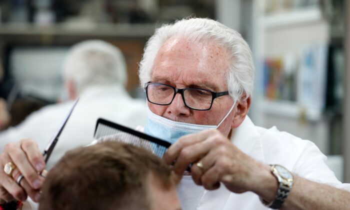 El barbero, Karl Manke, le corta el pelo a un cliente en su peluquería en Owosso, Mich., el 12 de mayo de 2020. (Jeff Kowalsky/AFP/Getty Images)
