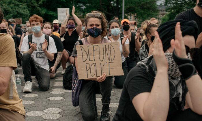 Manifestantes que denuncian el racismo sistémico en la aplicación de la ley y piden la supresión de los departamentos de policía, se arrodillan en el Parque María Hernández en el distrito de Brooklyn en la ciudad de Nueva York el 5 de junio de 2020. (Scott Heins/Getty Images)