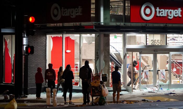 Los saqueadores roban una tienda de Target mientras los manifestantes se enfrentan a la policía en Oakland, California, el 30 de mayo de 2020. (Josh Edelson/AFP/Getty Images)