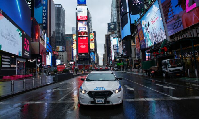 Un coche de la policía pasa por Times Square mientras llueve en la ciudad de Nueva York el 28 de marzo de 2020. (Kena Betancur/AFP vía Getty Images)