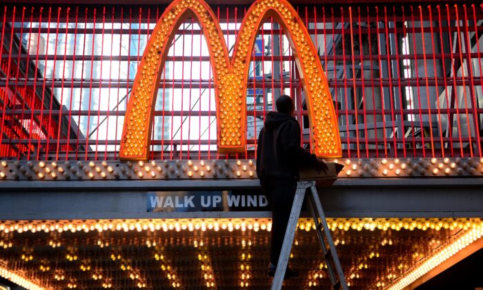 Un trabajador cambia las bombillas en la entrada de un McDonald's en la calle 42 cerca de Times Square en la ciudad de Nueva York, el 29 de enero de 2013. (Emmanuel Dunand/AFP vía Getty Images)