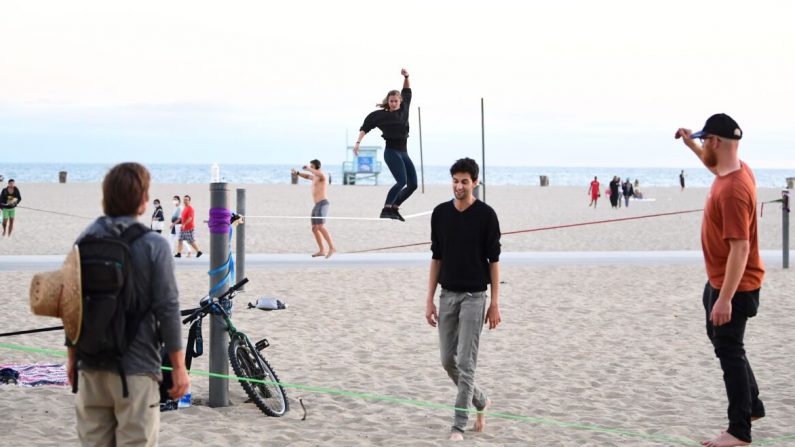 Los slackliners practican sus habilidades para caminar por la cuerda en Santa Mónica Beach, California, el 25 de junio de 2020. (Frederic J. Brown/AFP vía Getty Images)