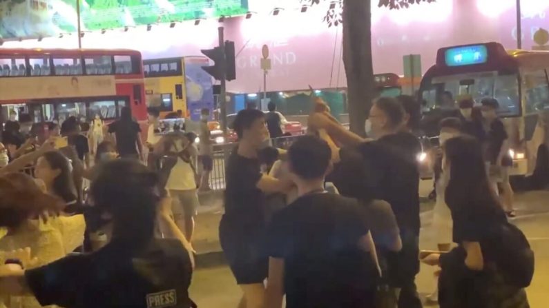Los espectadores intentan someter al asaltante con cuchillo en Kwun Tong, Hong Kong, el 12 de junio de 2020. (Jerry / The Epoch Times)