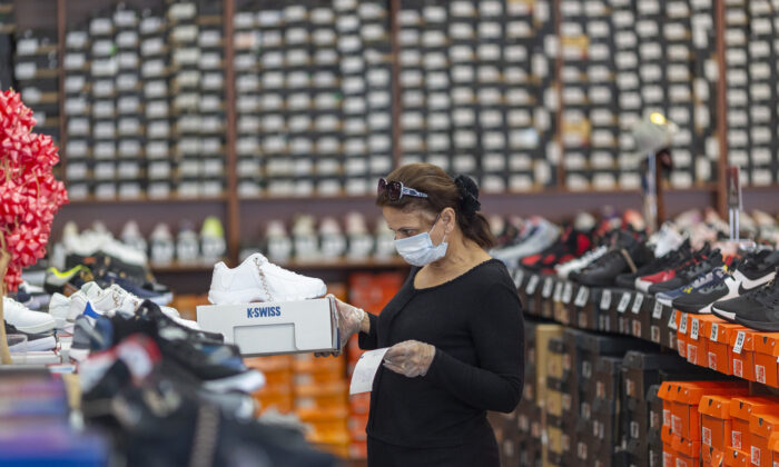 Un empleado almacena mercancía en una tienda de Shoe City mientras los negocios minoristas del condado de Los Ángeles reabren en Glendale, California, el 27 de mayo de 2020. (David McNew/Getty Images)