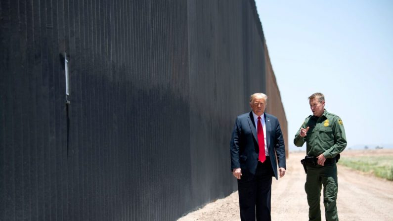 El presidente Donald Trump habla con el jefe de la Patrulla Fronteriza, Rodney Scott (der.), mientras participan en una ceremonia que conmemora las 200 millas del muro fronterizo en la frontera internacional con México en San Luis, Arizona, el 23 de junio de 2020. (Saul Loeb/AFP a través de Getty Images)