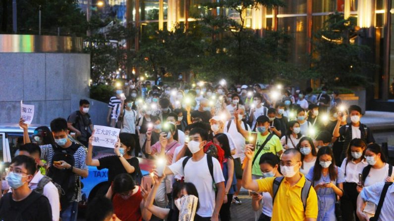 La gente marcha en Queen's Road en Central, Hong Kong, el 9 de junio de 2020. (Song Bilong/The Epoch Times)