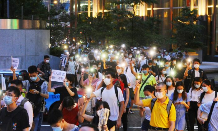 La gente marcha en Queen's Road en Central, Hong Kong, el 9 de junio de 2020. (Song Bilong/The Epoch Times)