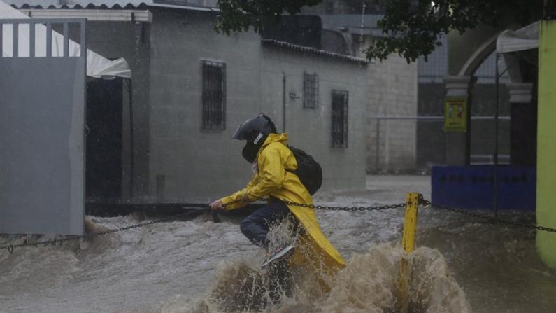 Una persona intenta cruzar una calle inundada debido al paso de la tormenta tropical Amanda en San Salvador (El Salvador). EFE/Rodrigo Sura
