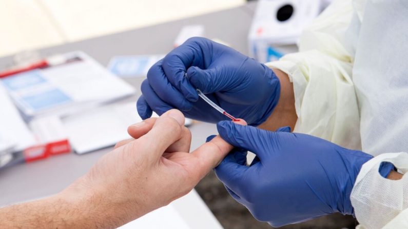 Un trabajador de salud toma una gota de sangre para una prueba de anticuerpos COVID-19 en Torrance, California, el 5 de mayo de 2020. (Valerie Macon/AFP a través de Getty Images)