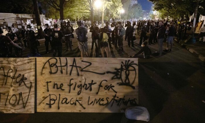 Manifestantes se confrontan con la policía cerca de una barricada que  construyeron y marcaron con la frase "Zona Autónoma Casa de Negros" frente al Parque Lafayette cerca de la Casa Blanca en Washington el 22 de junio de 2020. (Roberto Schmidt/AFP via Getty Images)