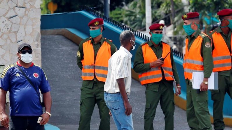 Varios policías con tapabocas montan guardia en una esquina, el 30 de junio de 2020 en La Habana (Cuba). EFE/Ernesto Mastrascusa