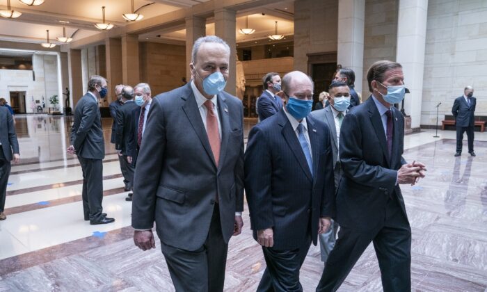 El líder de la minoría del Senado Chuck Schumer (D-N.Y.), a la izquierda, sale en un momento de silencio en honor a George Floyd y el movimiento Black Lives Matter en el Salón de la Emancipación del Capitolio de EE.UU. en Washington el 4 de junio de 2020. (Sarah Silbiger/Getty Images)