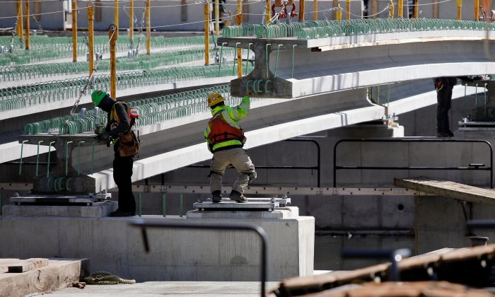 Los trabajadores de la construcción guían una pieza de un puente a su lugar, en Baltimore, Maryland, el 26 de marzo de 2018. (David Gannon/AFP/Getty Images)
 
