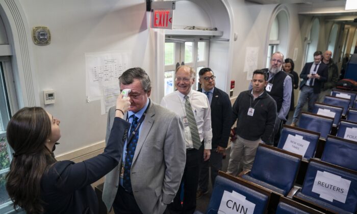 Los trabajadores de la Oficina del Médico de la Casa Blanca controlan la temperatura corporal de los periodistas en la sala de prensa de la Casa Blanca en Washington el 17 de marzo de 2020. (Drew Angerer / Getty Images)