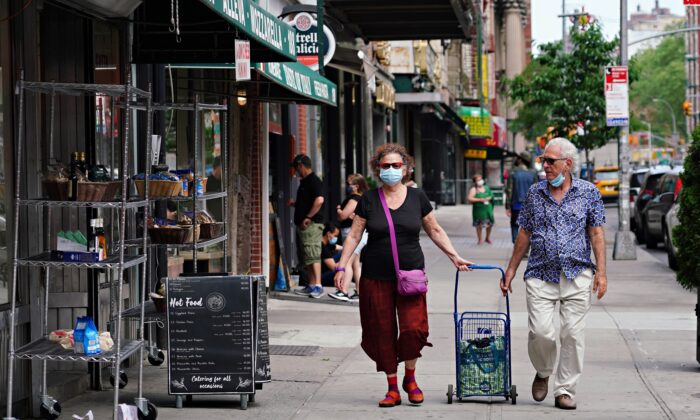 Personas con máscaras protectoras caminan por la Pequeña Italia durante la pandemia de COVID-19 en la ciudad de Nueva York el 29 de mayo de 2020. (Cindy Ord/Getty Images)