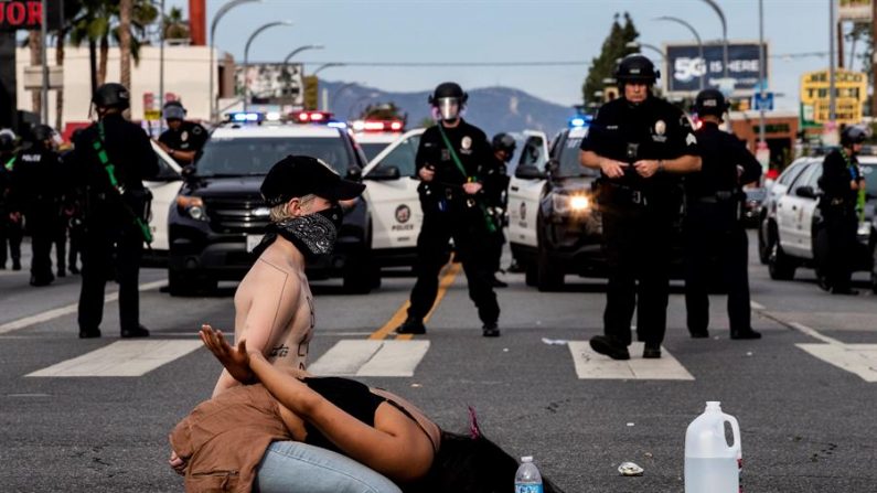 Manifestantes esperan su arresto por parte de la policía durante las protestas por la muerte de George Floyd, en Van Nuys, Los Ángeles, California, EE. UU., El 1 de junio de 2020. EFE/EPA/ETIENNE LAURENT
