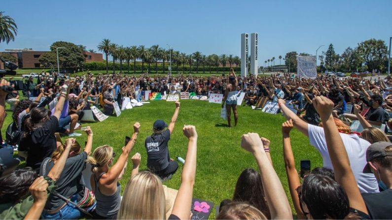 Manifestantes sostienen sus puños mientras se arrodillan en la Autopista de la Costa del Pacífico (PCH) en Newport Beach, California, el 3 de junio de 2020 durante una protesta por la muerte de George Floyd. (APU GOMES/AFP vía Getty Images)