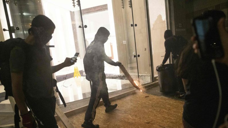 Alborotadores vandalizan un edificio de oficinas en Washington el 31 de mayo de 2020. (Roberto Schmidt/AFP vía Getty Images)
