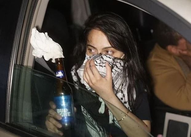 Una mujer identificada como Urooj Rahman sostiene un cóctel molotov en una imagen fija de un video de vigilancia. (Oficina del Fiscal de Estados Unidos-Distrito Este de Nueva York)