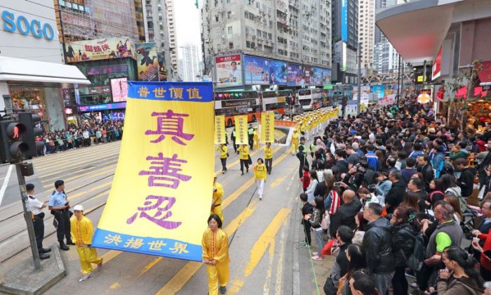 Practicantes de Falun Gong sostienen banderas amarillas en un desfile en Hong Kong el 9 de diciembre de 2018. (Li Yi/The Epoch Times)
