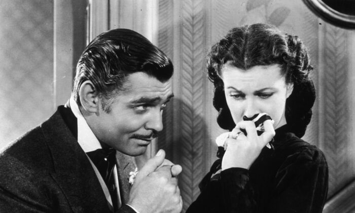 El actor Clark Gable en su papel de Rhett Butler besando la mano de una llorosa Scarlett O'Hara, interpretada por Vivien Leigh, en 'Lo que el viento se llevó'. (Archivo Hulton / Getty Images)