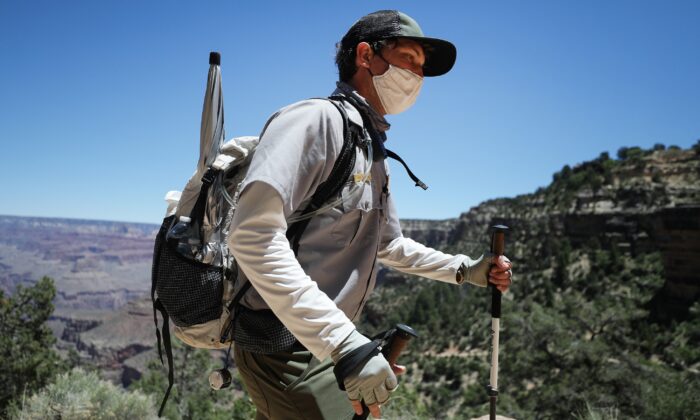 Un guardabosques usa una mascarilla mientras patrulla el sendero Bright Angel del Parque Nacional del Gran Cañón, que se ha reabierto parcialmente los fines de semana durante la pandemia COVID-19, en el Parque Nacional del Gran Cañón, Arizona, el 25 de mayo de 2020. (Mario Tama/Getty Images)