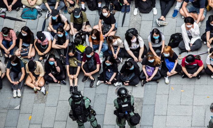 La policía antidisturbios detiene a un grupo de personas durante una protesta en el distrito de Causeway Bay de Hong Kong el 27 de mayo de 2020, mientras la legislatura de la ciudad debate sobre una ley que prohíbe insultar el himno nacional de China. (Isaac Lawrence/AFP vía Getty Images)