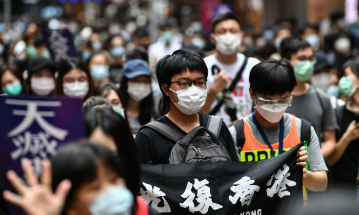 Cientos de manifestantes marchan por una calle durante un acto prodemocracia en contra de un nuevo proyecto de ley de seguridad en Hong Kong el 24 de mayo de 2020. (Anthony Wallace/AFP vía Getty Images)