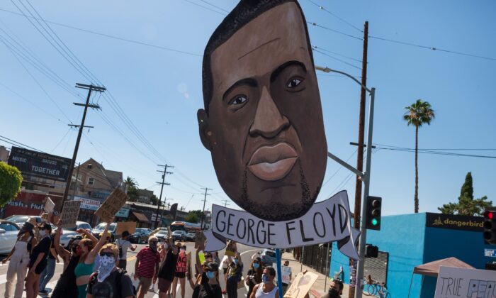 Un pequeño grupo de manifestantes pacíficos sostienen carteles y gritan consignas en memoria de George Floyd en la sección de Silverlake de Los Ángeles, California, el 11 de junio de 2020. (Robyn Beck/AFP/Getty Images)