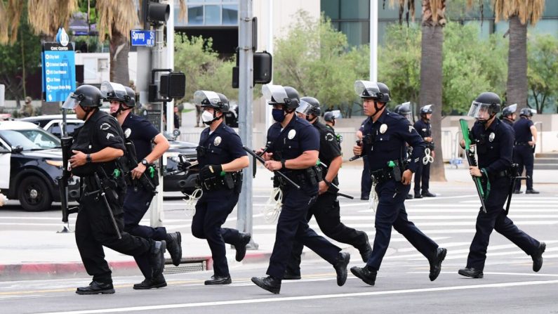 Oficiales del Departamento de Policía de Los Ángeles corren hacia la formación durante una marcha por la muerte de George Floyd, frente al Ayuntamiento de Los Ángeles en Los Ángeles, California, el 1 de junio de 2020. (Frederic J. Brown/AFP a través de Getty Images)