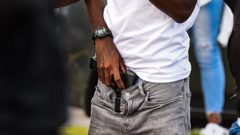 Un hombre sostiene una pistola mientras un grupo bloquea la carretera, al lado de un restaurante quemado de Wendy´s, en Atlanta, Georgia, el 16 de junio de 2020. (Chandan Khanna/AFP a través de Getty Images)