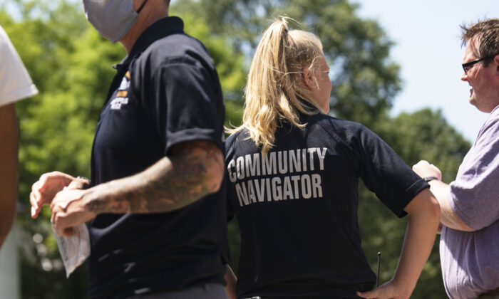 Los miembros del programa Community Navigator, del Departamento de Policía de Minneapolis, hablan con personas reunidas cerca de una escena del crimen, en Minneapolis, Minn., El 16 de junio de 2020. (Stephen Maturen/Getty Images)
