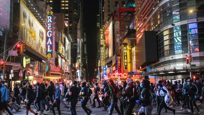 Los manifestantes se apresuran a pasar por Times Square después de las 11 p.m. ya que el toque de queda comenzó en Nueva York el 1 de junio de 2020. (John Moore/Getty Images)