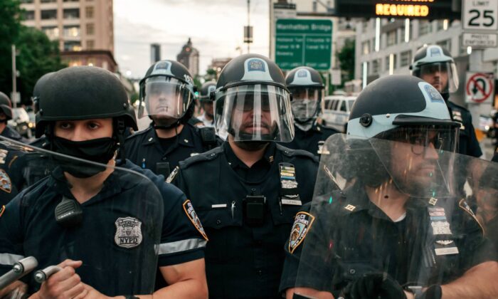 La policía de Nueva York bloquea la entrada del puente de Manhattan mientras cientos de personas que protestan por la brutalidad policial y el racismo sistémico intentan cruzar desde Brooklyn después de que el 2 de junio de 2020 entrara en vigor un toque de queda en toda la ciudad. (Scott Heins/Getty Images)