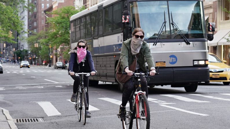La gente anda en bicicleta mientras usa protectores faciales durante la pandemia del virus del PCCh en la ciudad de Nueva York, Nueva York, el 20 de mayo de 2020. (Cindy Ord/Getty Images)