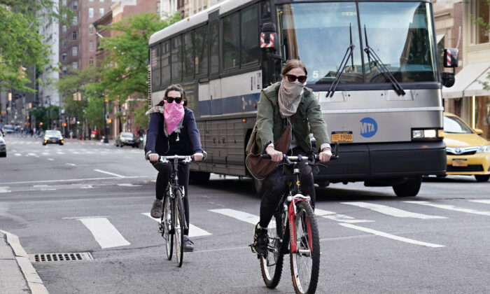 Las personas andan en bicicleta mientras se cubren la cara durante la pandemia del virus CCP en la ciudad de Nueva York, Nueva York, el 20 de mayo de 2020. (Cindy Ord / Getty Images)