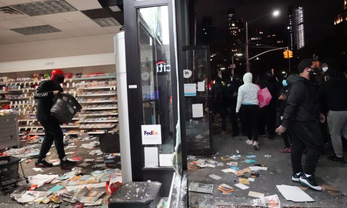 La gente saquea una tienda durante las manifestaciones sobre la muerte de George Floyd por un oficial de policía de Minneapolis en Nueva York el 1 de junio de 2020. (Bryan R. Smith / AFP a través de Getty Images)