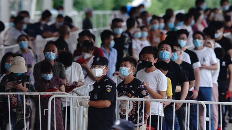 Las personas que han tenido contacto con el mercado mayorista de Xinfadi o con alguien que ha tenido contacto, se ponen en fila para una prueba de ácido nucleico para COVID-19 en un centro de pruebas el 17 de junio de 2020 en Beijing, China. (Lintao Zhang/Getty Images)