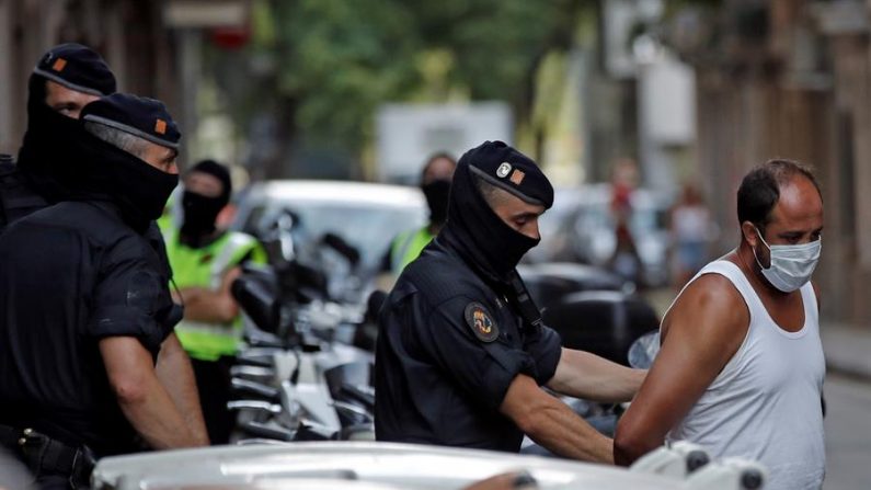 Mossos d'esquadra custodian a uno de los 2 detenidos en la operación contra el terrorismo yihadista que llevan a cabo desde primera hora de la mañana el 14 de julio de 2020 en el distrito de Ciutat Vella de Barcelona, Cataluña (España). EFE/Toni Albir