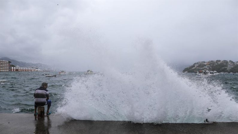 Un hombre observa una ola que golpea el malecón el 7 de julio de 2020 en el balneario de Acapulco, estado de Guerrero (México). EFE/David Guzmán