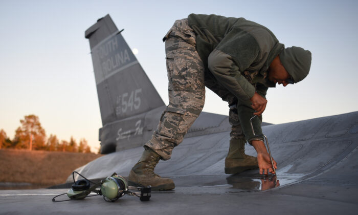 Tecnología de la Fuerza Aérea de los Estados Unidos. El sargento Brad Steward asegura un panel de aviones después de la llegada de un caza F-16 a la base aérea de Kallax en Luleå, Suecia, el 16 de mayo de 2019, en preparación para el ejercicio Desafío Ártico 2019. (Fotografía de la Guardia Nacional Aérea de EE.UU. por el Sargento Mayor Edward Snyder)