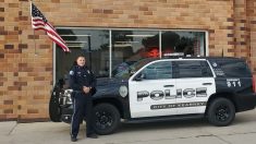 Policía de Nebraska es captado arreglando una bandera de EE. UU. caída fuera de un taller para autos